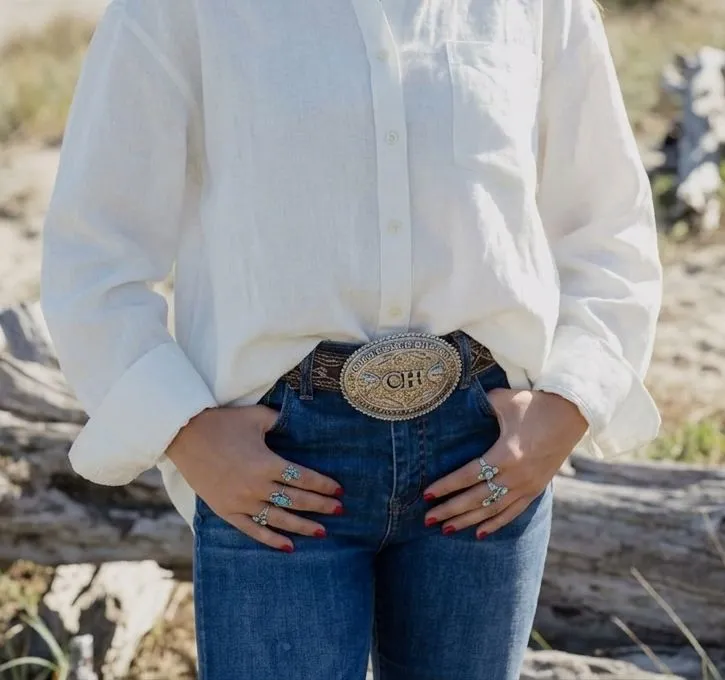Close up of a silver engraved western belt buckle on linen fabric