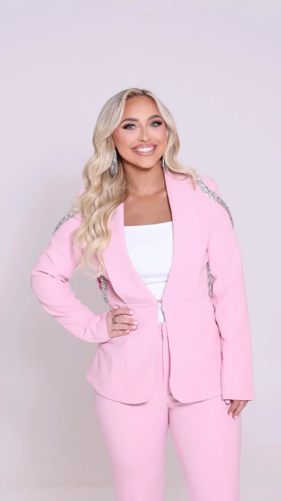 Model with glowing skin and peach lip gloss modeling a fresh summer makeup look.