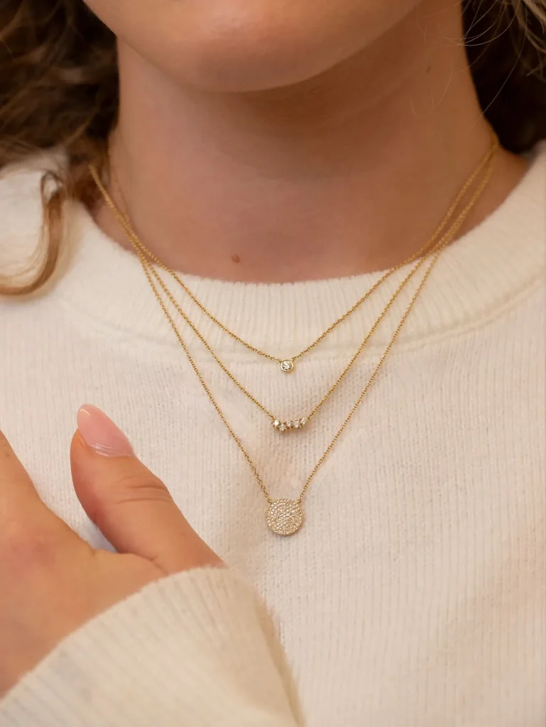 Detail shot of a gold tennis bracelet and a white V-neck sweater vest