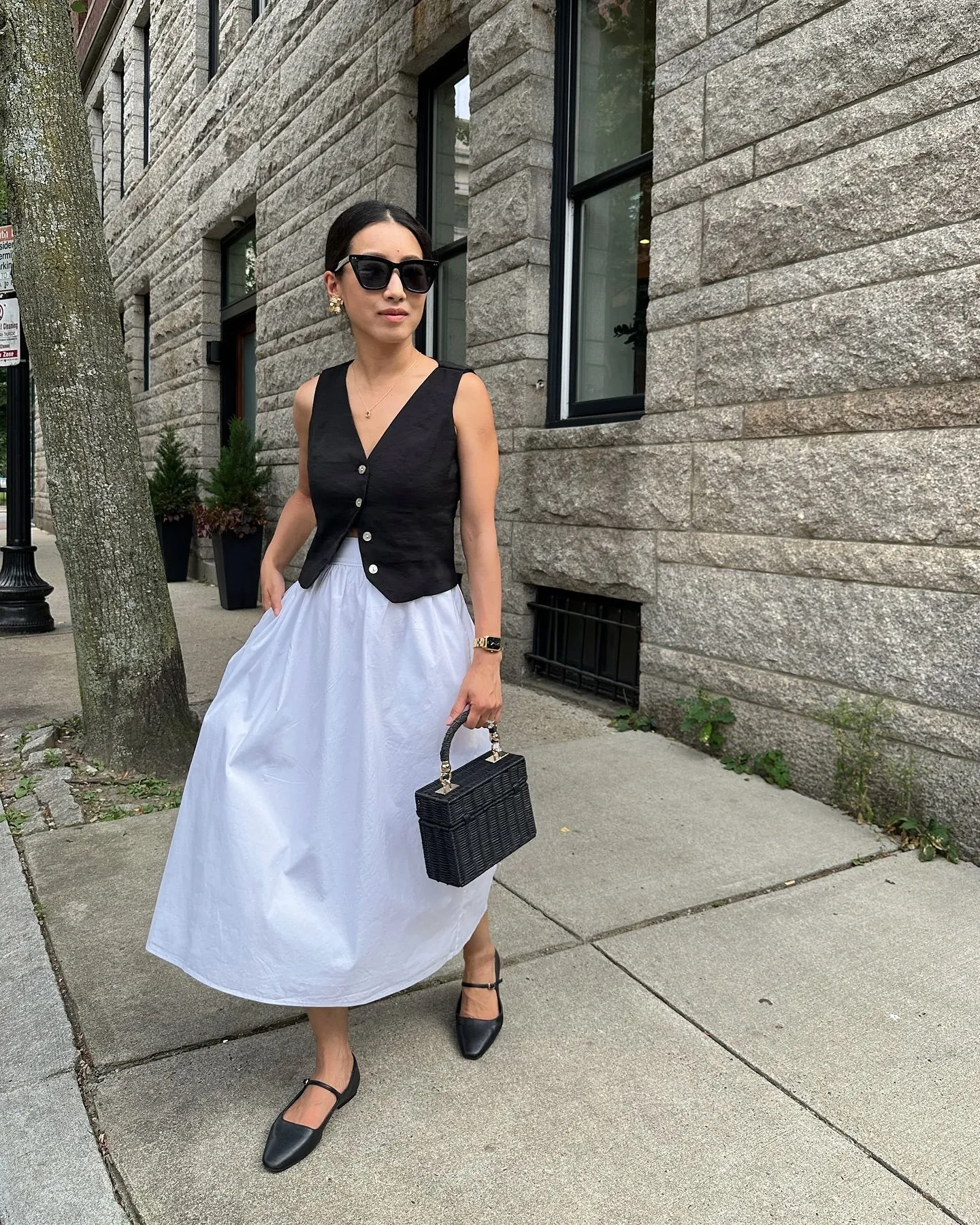 Woman wearing a budget-friendly ivory cotton A-line midi skirt in a summer garden