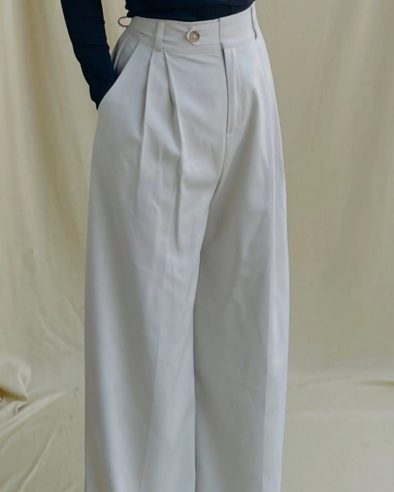 Close up of ivory linen high-waisted trousers and crisp cotton shirt for Newport mansion tour