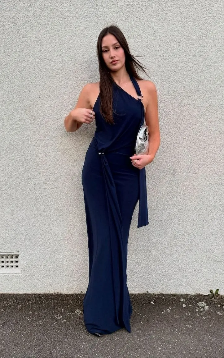 Woman in a navy jersey dress and baseball cap