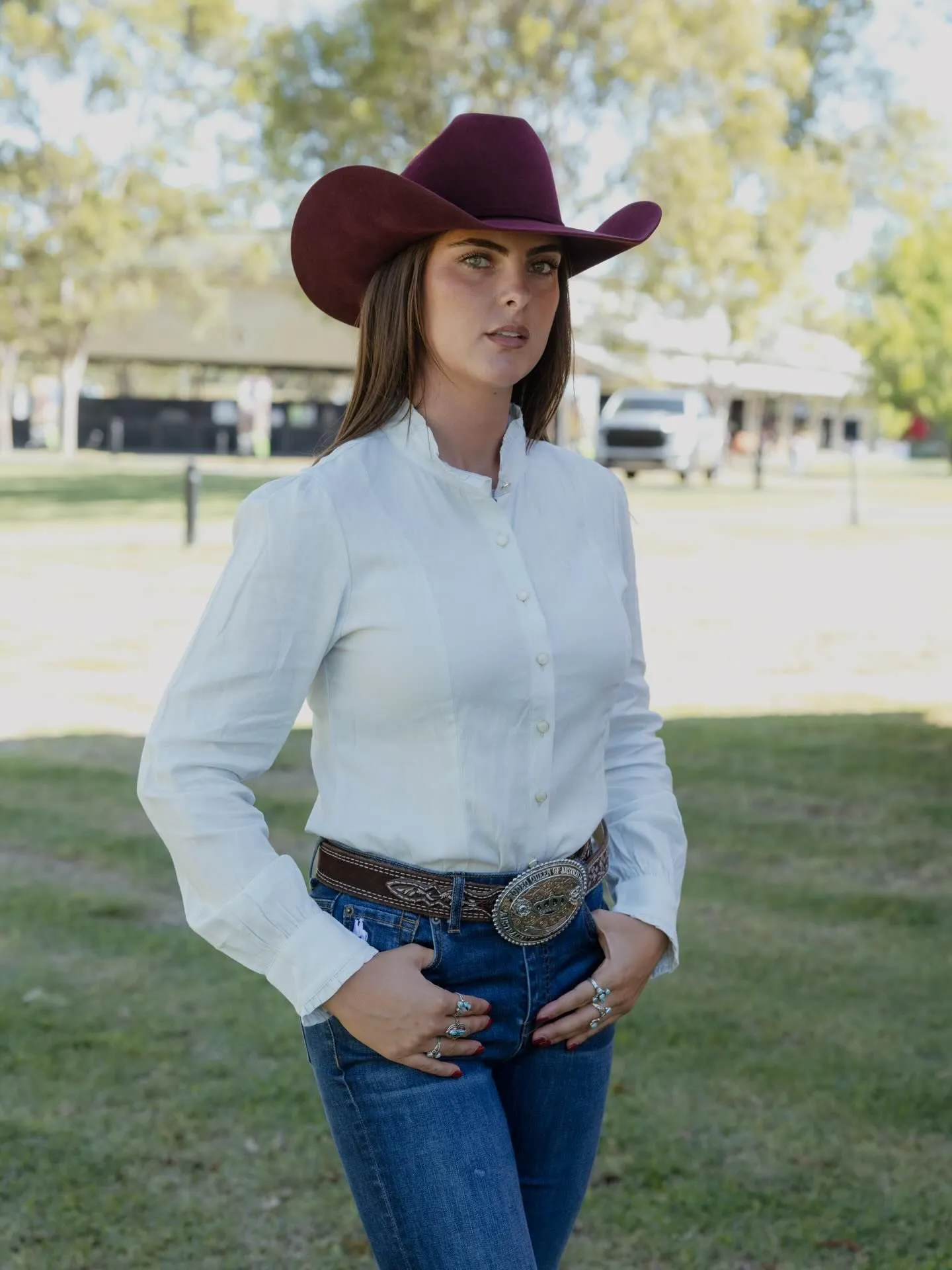 Coastal cowgirl wearing an oversized linen shirt with a chunky leather western belt