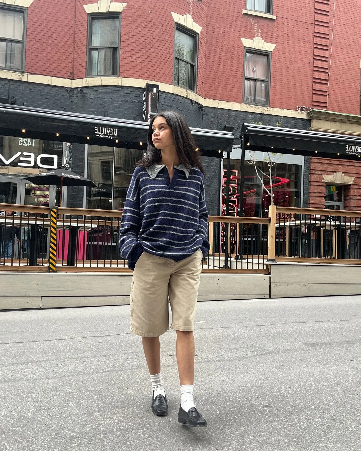 Woman wearing a navy striped top and tailored chino shorts for a coastal walk in Newport