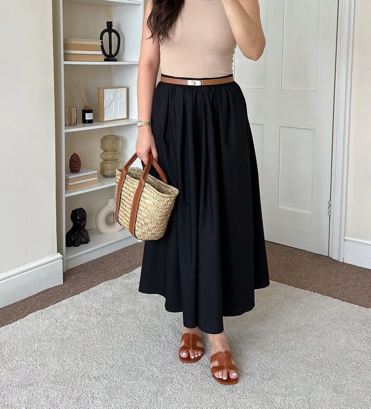 Close-up of high-waisted navy blue poplin A-line skirt with a gold buckle belt