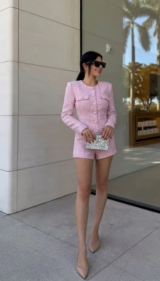 Woman wearing an elegant pastel pink tweed romper with nude leather flats for a mansion tour