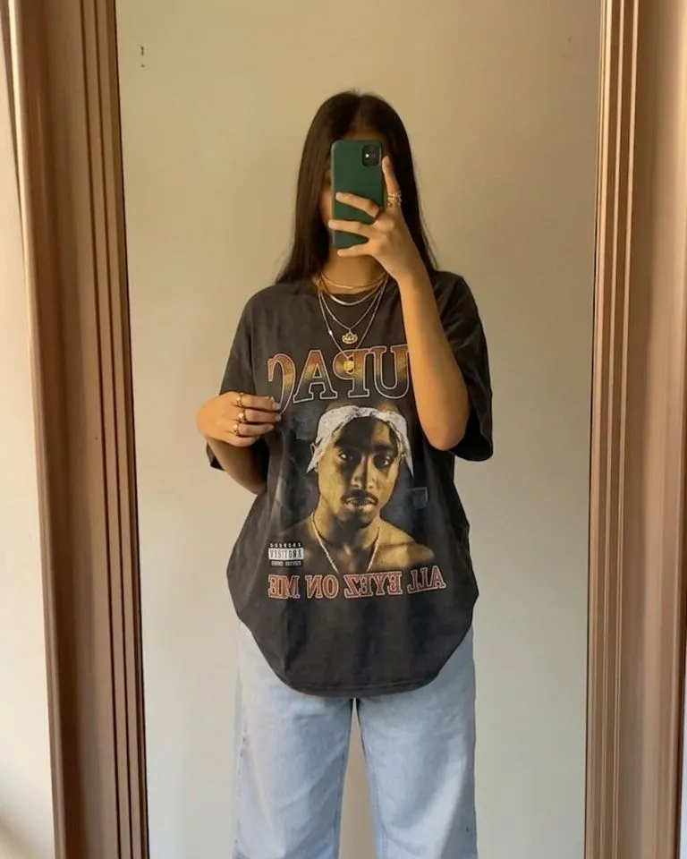 Woman wearing a vintage graphic tee layered with delicate gold jewelry