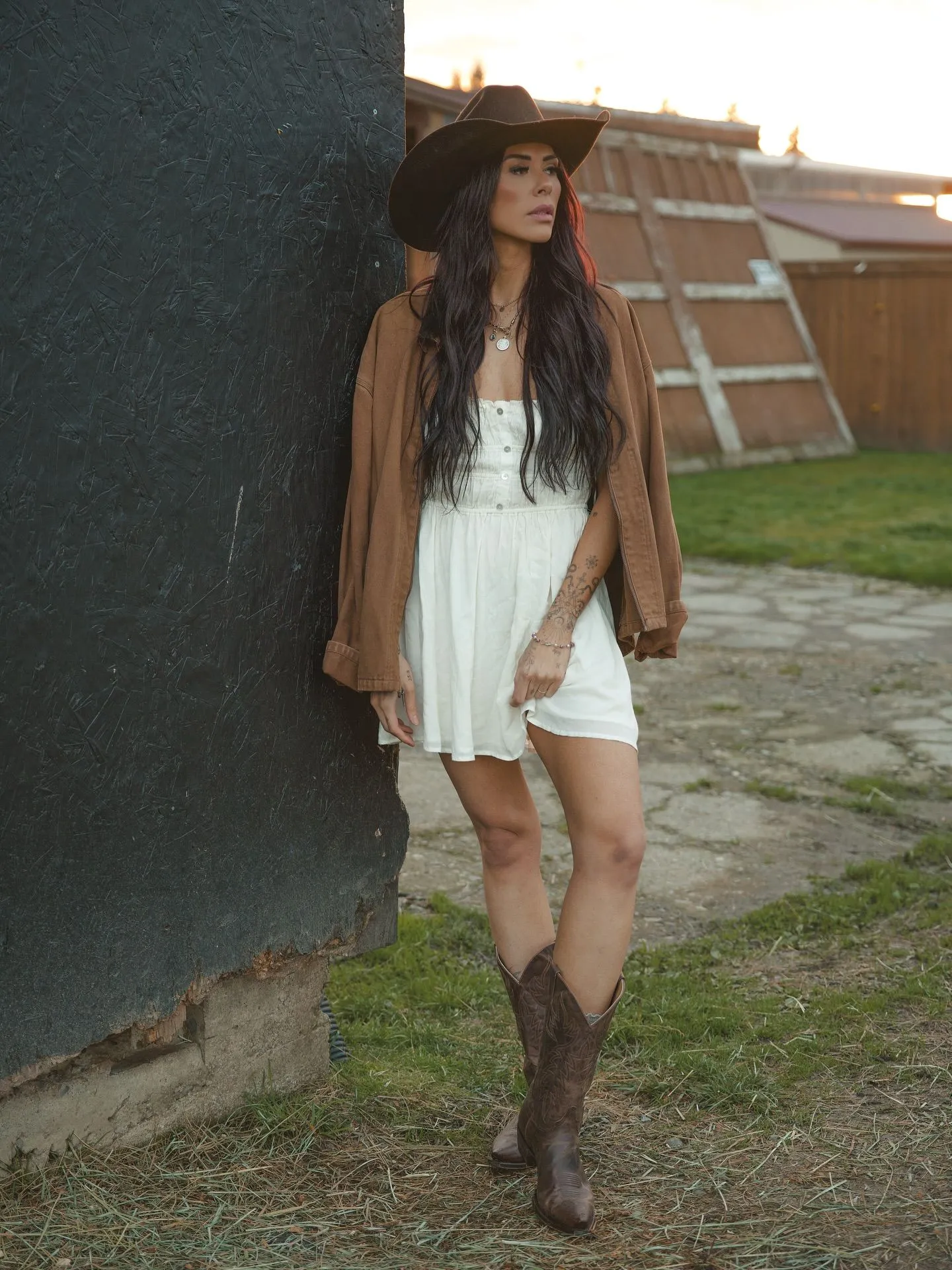 Model in a white eyelet dress and tan cowboy boots for a summer concert