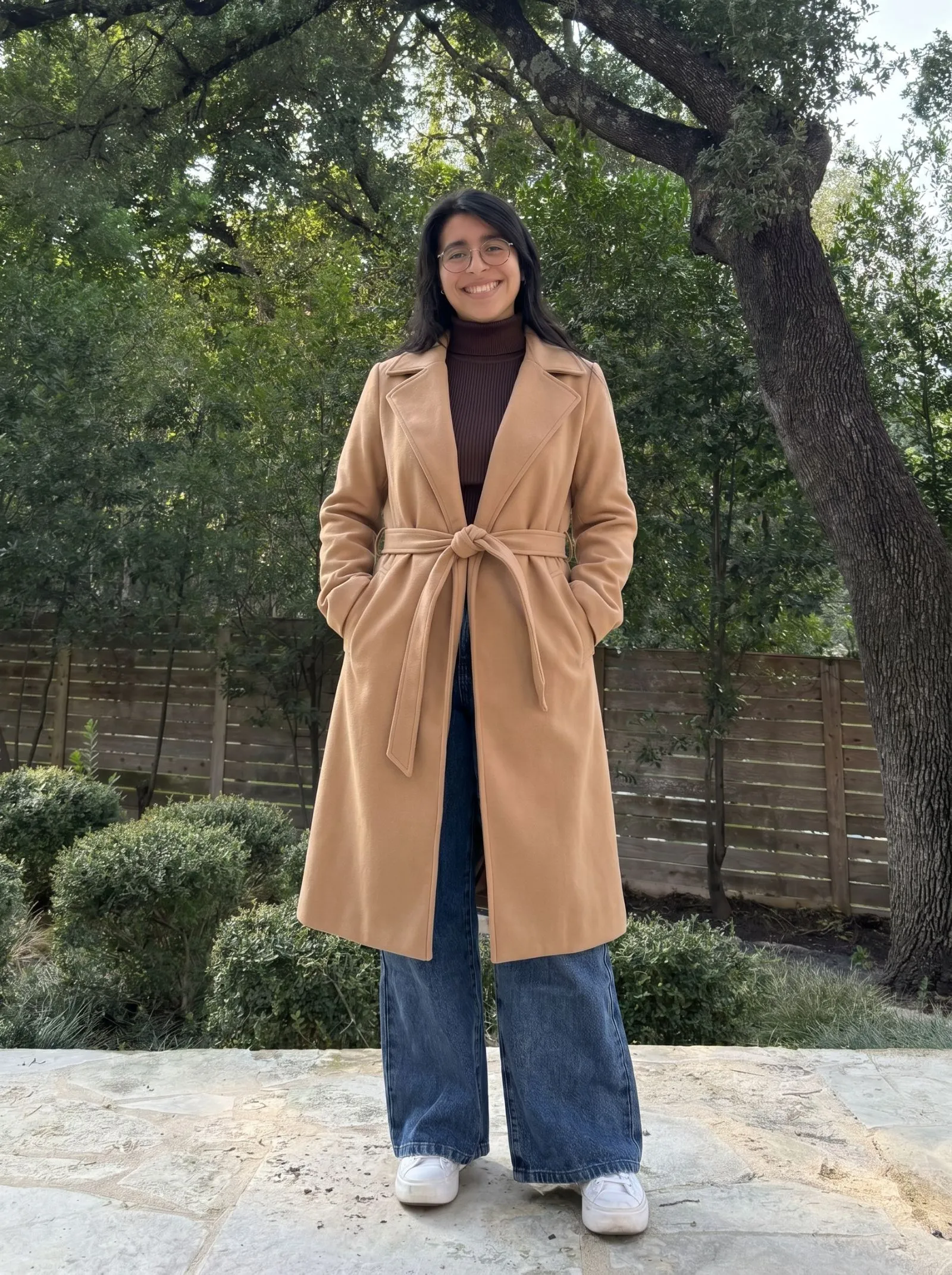 Curvy petite woman wearing a camel belted midi trench coat and espresso ribbed turtleneck