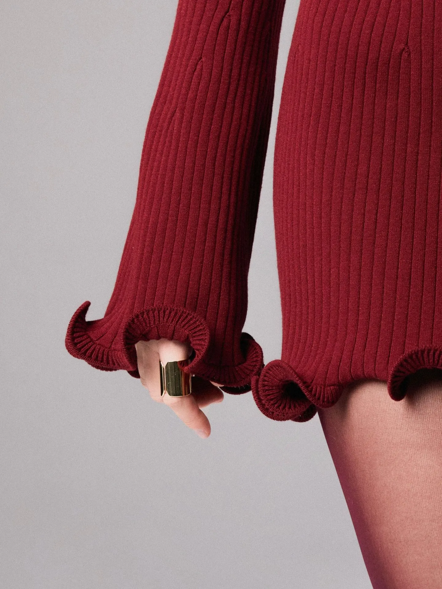 Close-up of ribbed knit texture on a burgundy sweater dress