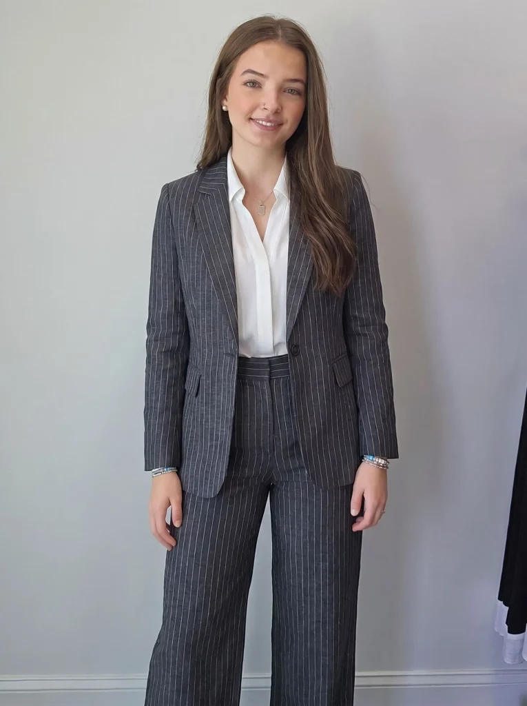 Female CEO wearing a tailored charcoal pinstripe linen pantsuit for evening networking