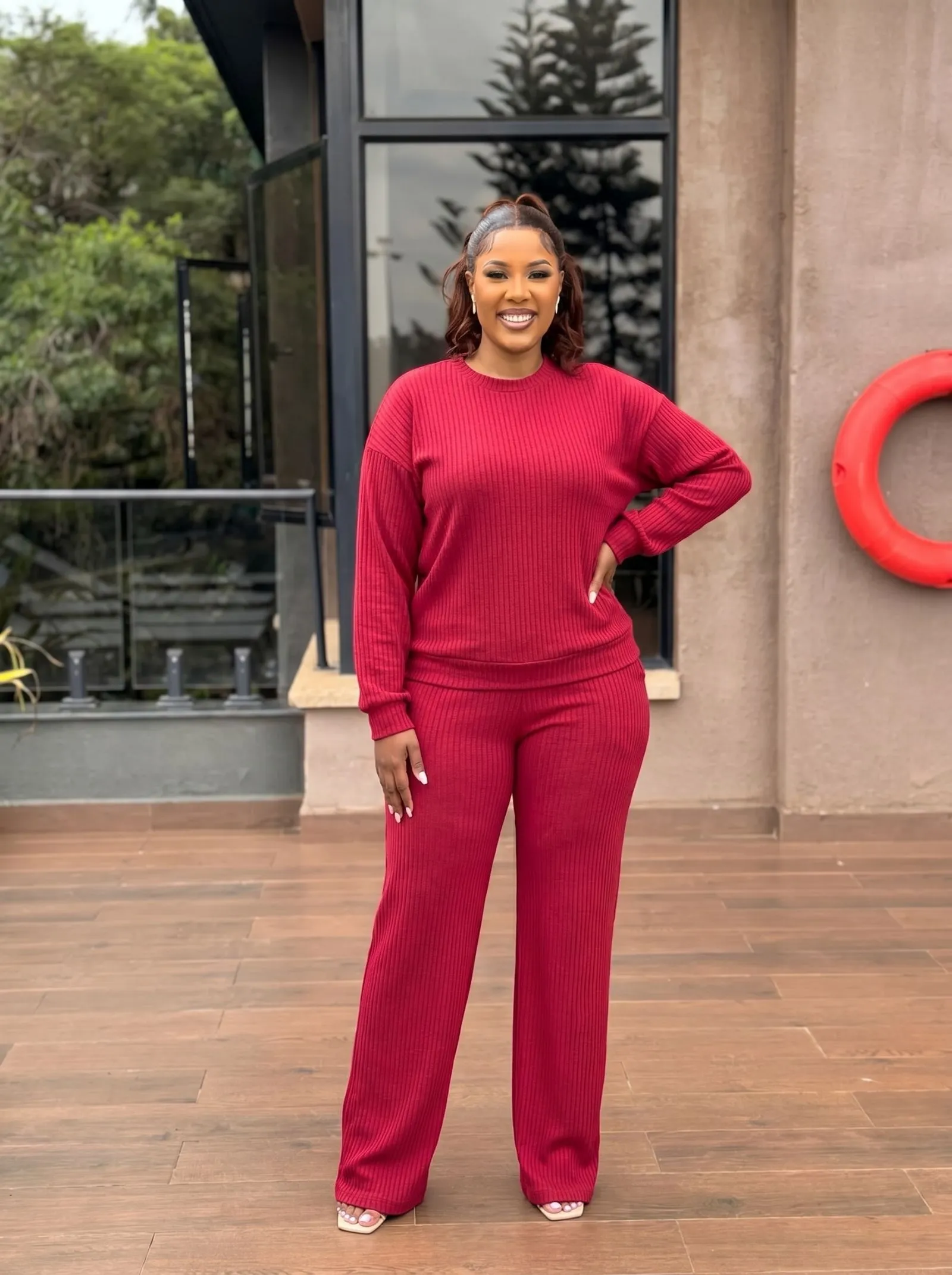 Plus size woman wearing a crimson ribbed knit matching set at a desk