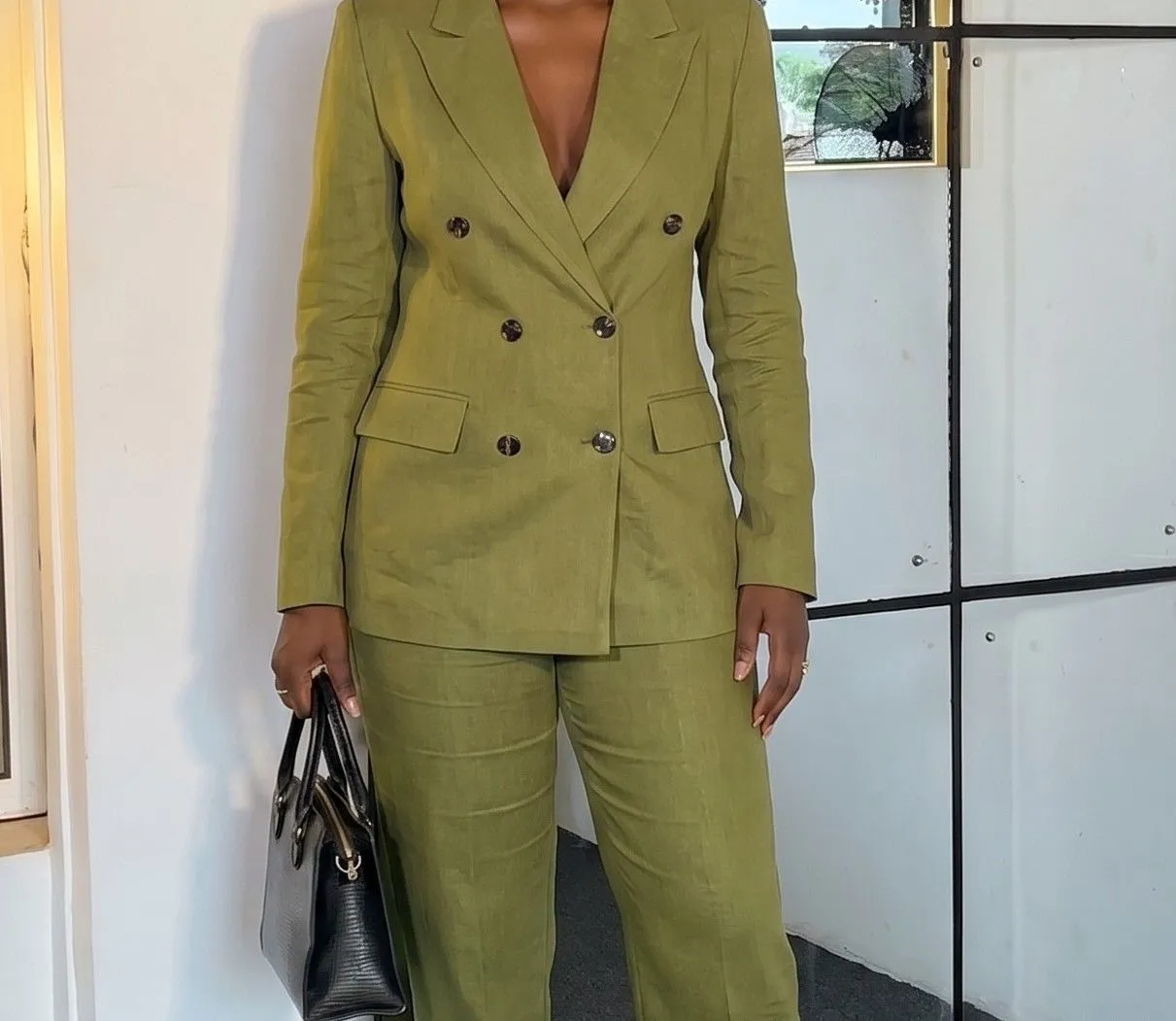 Close up of tortoiseshell buttons on an olive green double-breasted linen blazer