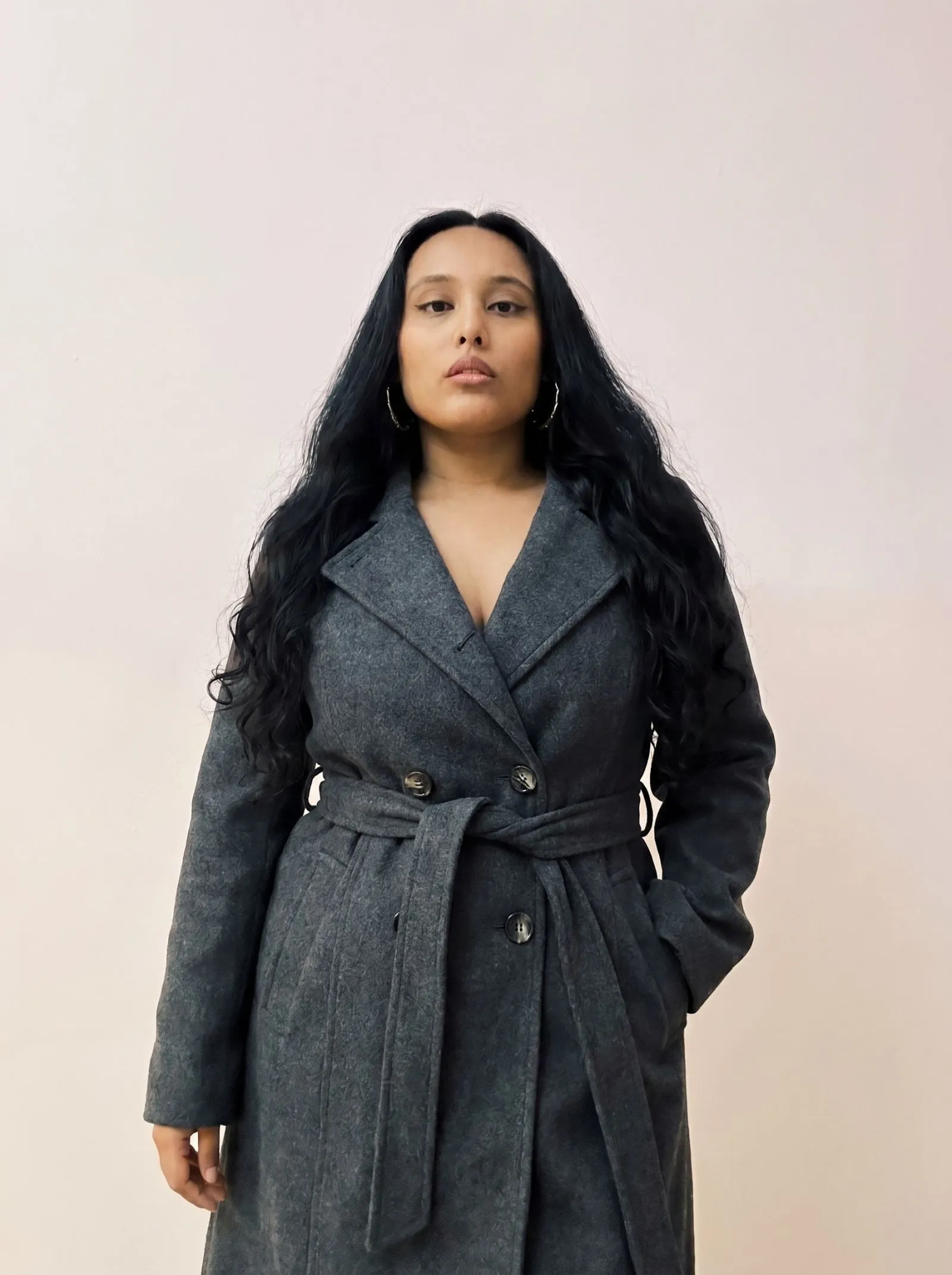 Woman with hourglass figure in belted wool coat for fall