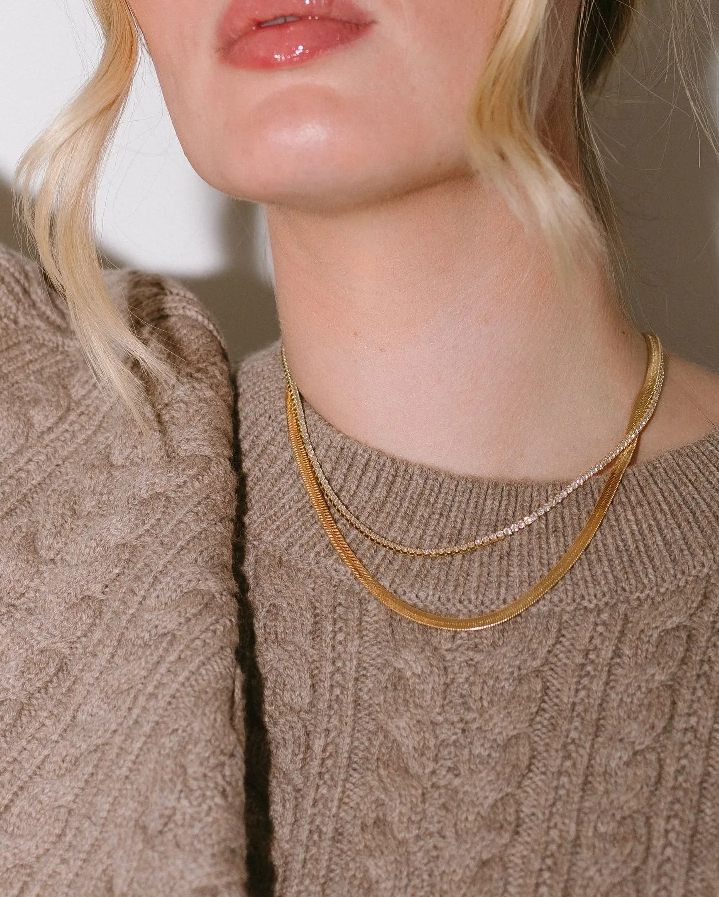 Chunky gold hoops and layered necklaces styled with a sweater