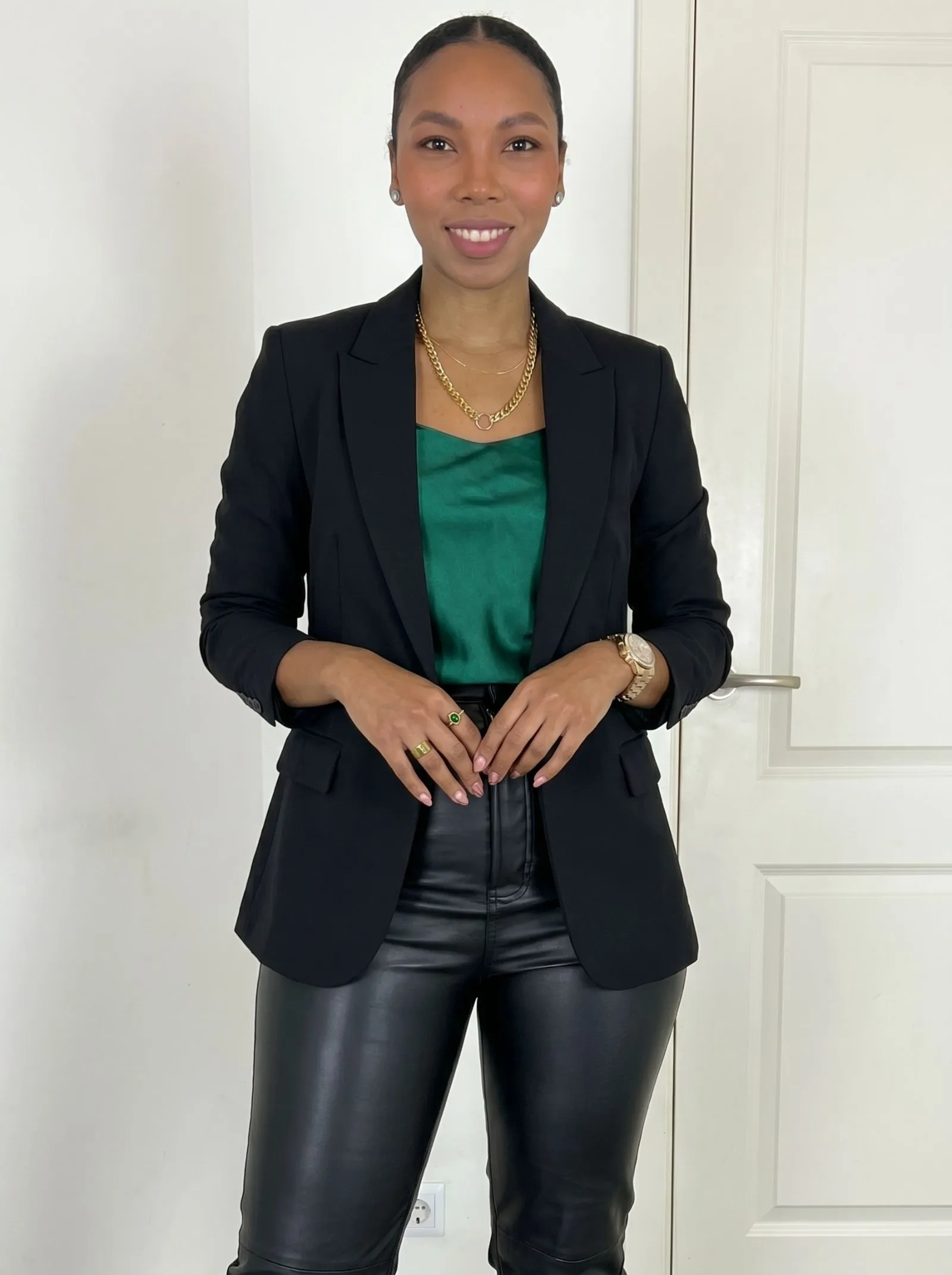 Woman wearing black leather pants and a green silk camisole for a night out