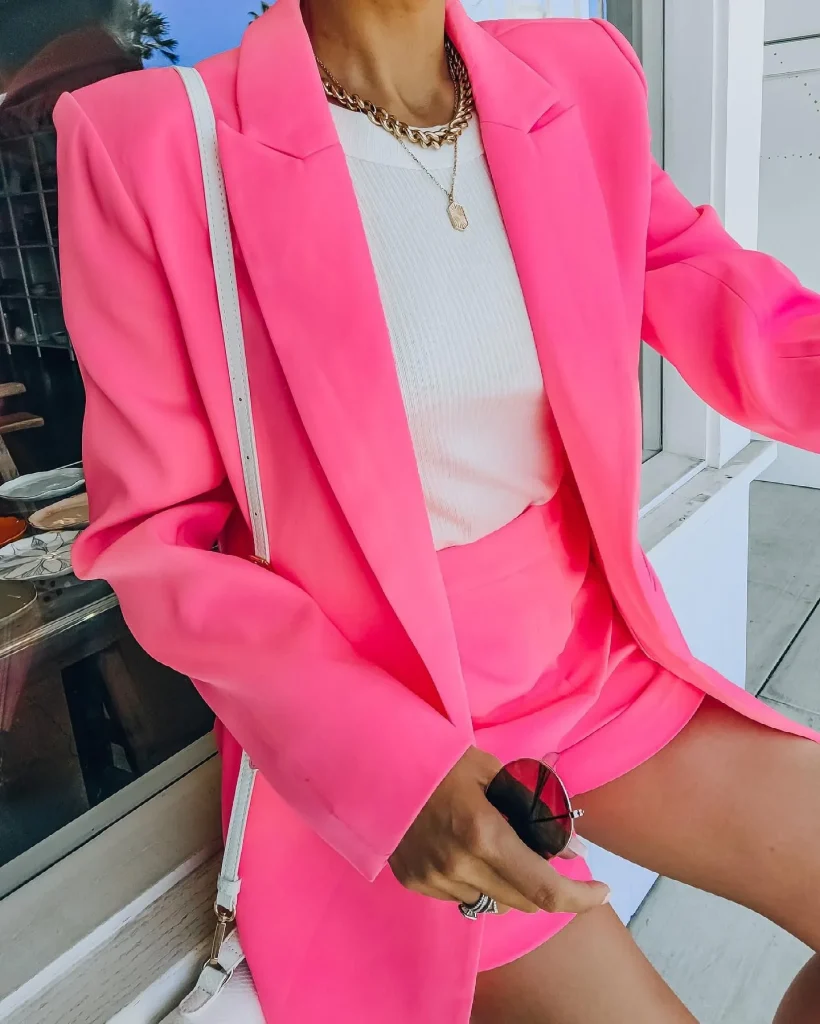 Close up of a neon pink satin 80s blazer with shoulder pads