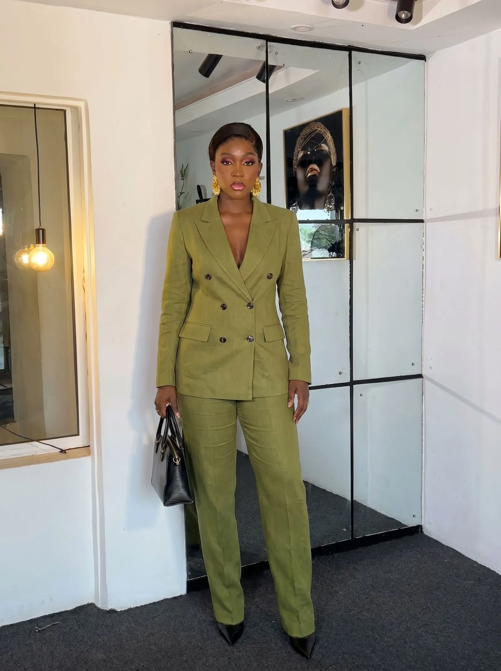 Woman wearing a tailored double-breasted olive green linen suit for a creative pitch presentation