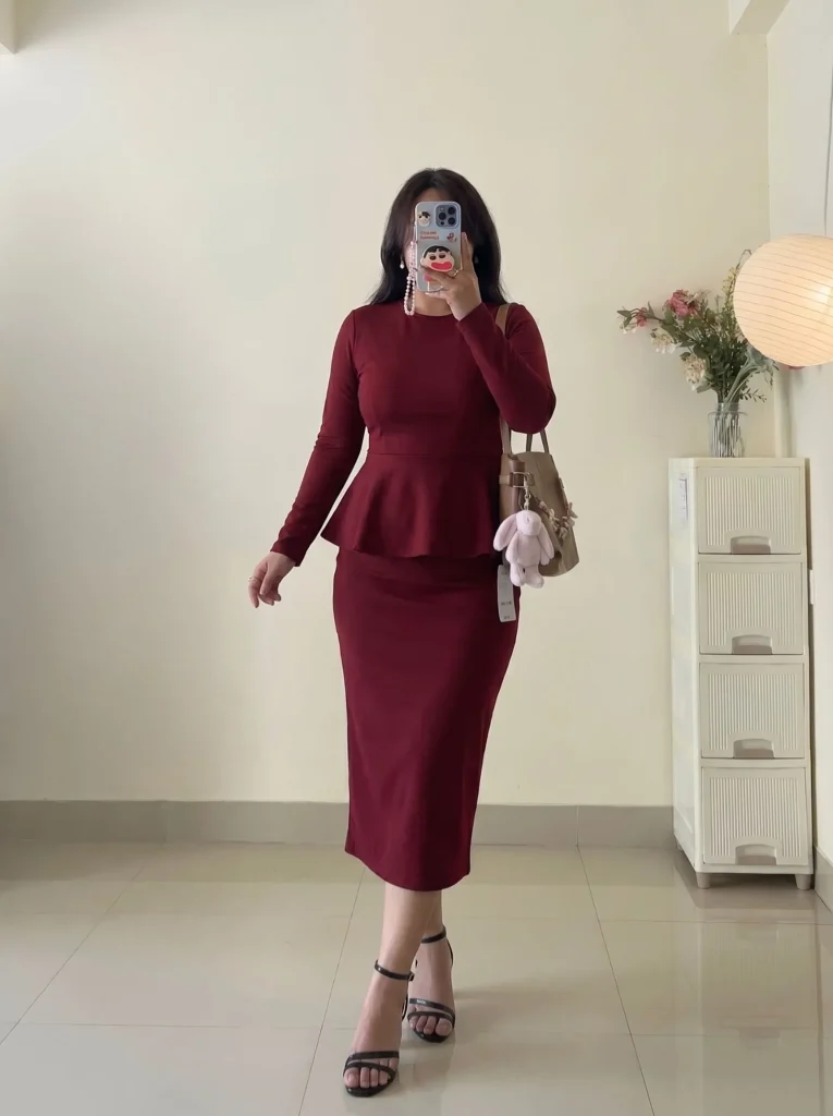 Curvy woman in oxblood peplum top and pencil skirt