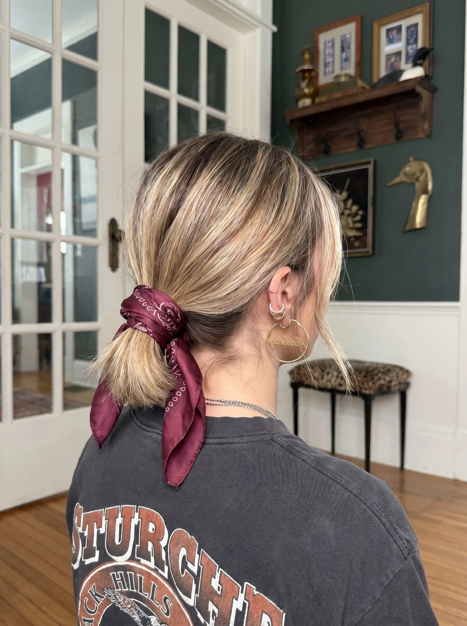 Low ponytail for short hair wrapped in a burgundy silk bandana