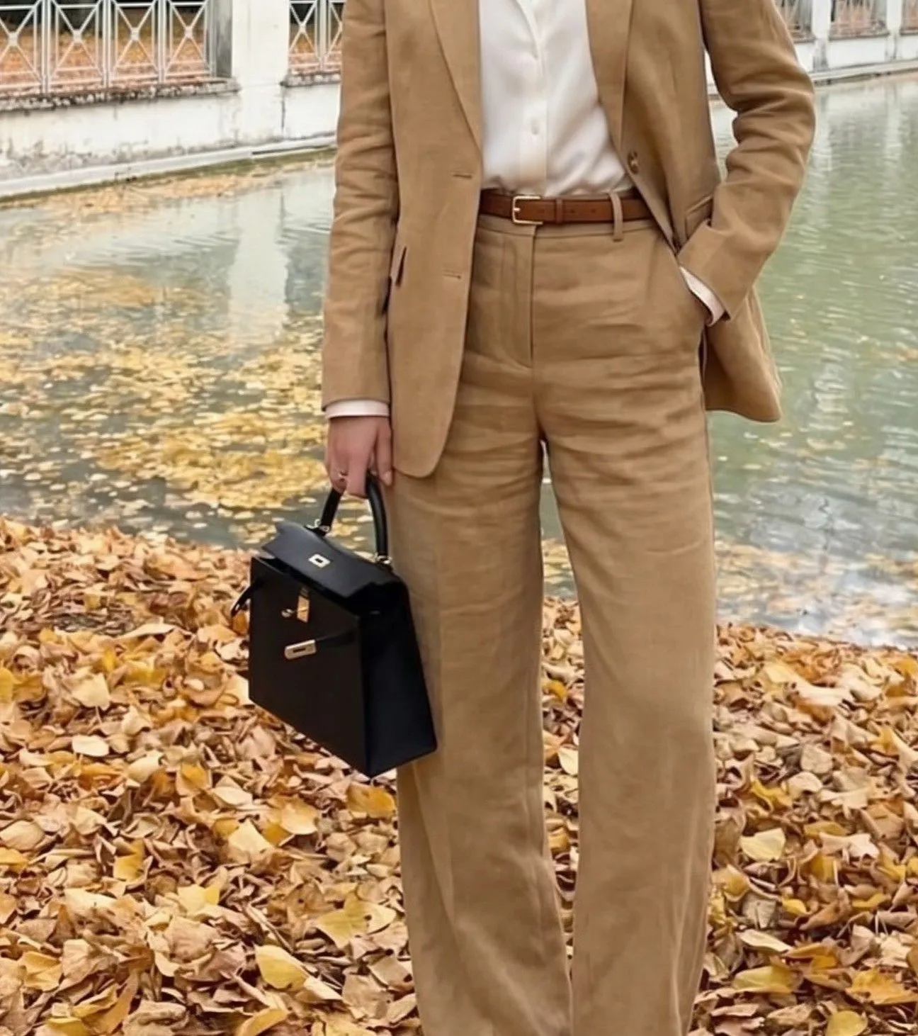 Close up detail of a camel linen blazer with a gold watch for summer travel