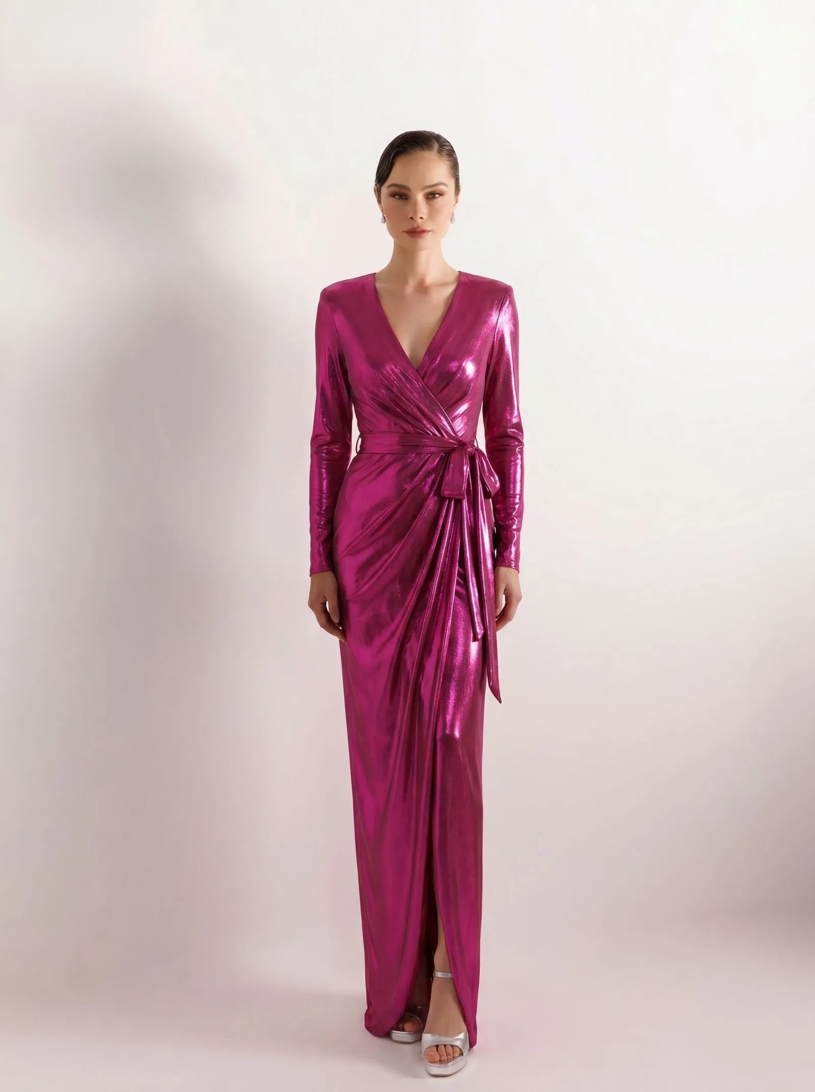 A woman wearing a fuchsia metallic wrap dress for a cruise dinner.